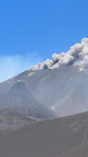 Mount Etna active eruption with ash plume rising from summit